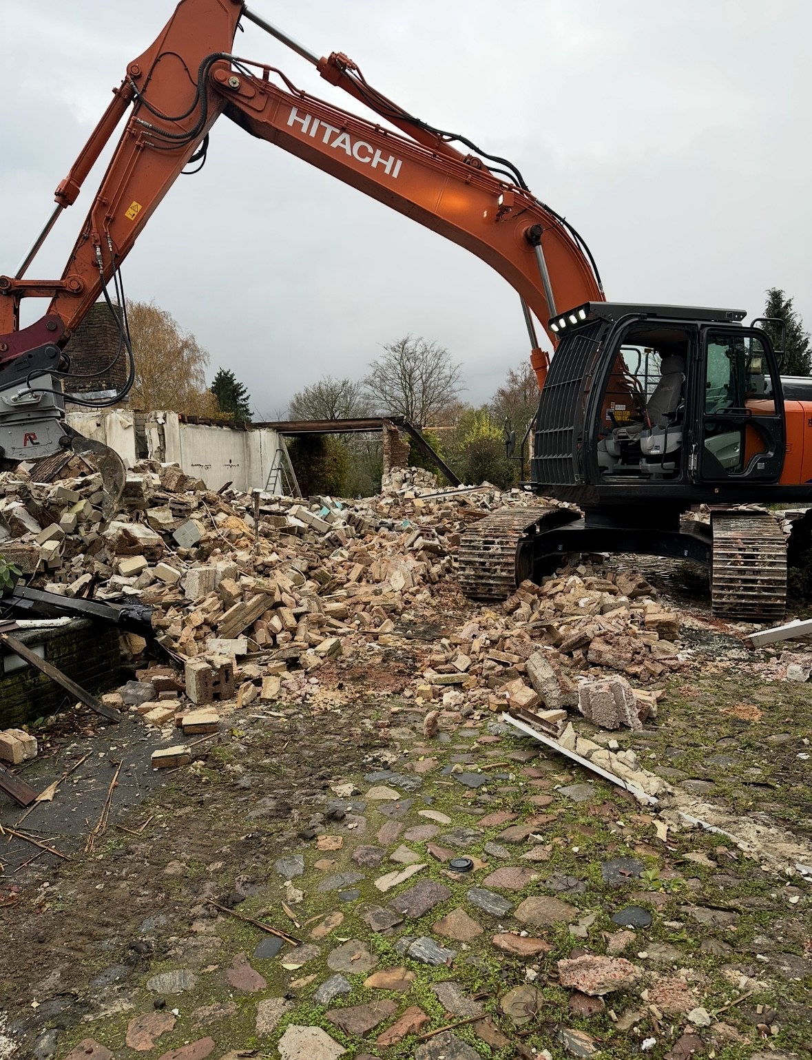 Abbruch eines Bestandsgebäudes mit Hitachi-Kettenbagger auf Ziegelschutt