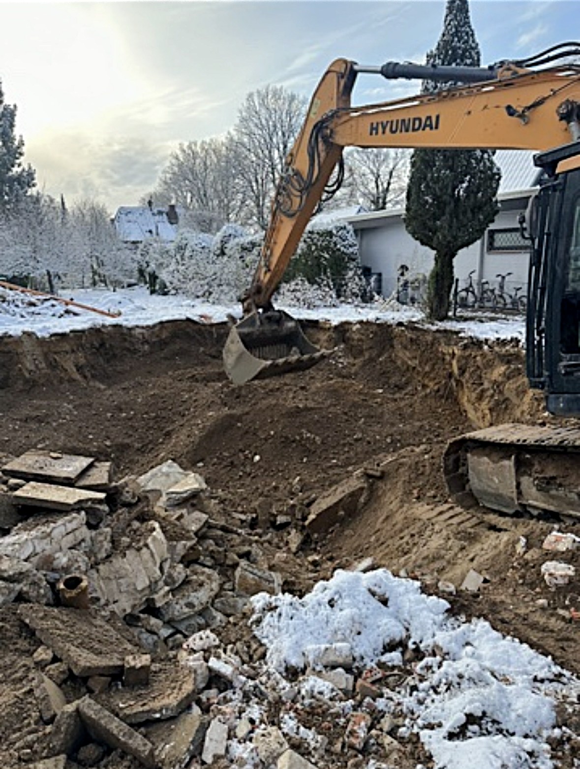 Aushub einer Baugrube im Winter mit Hyundai-Bagger